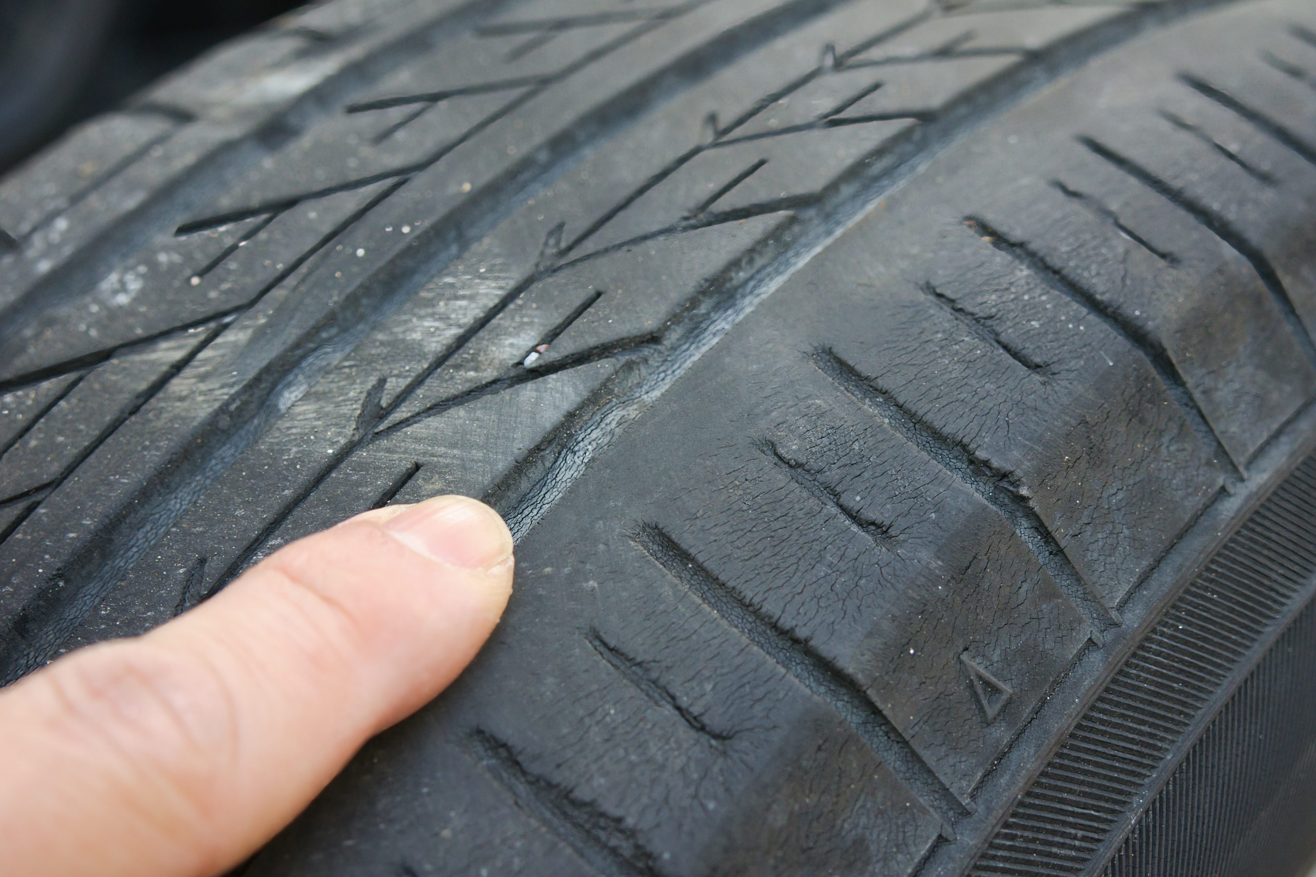 タイヤのスリップサインの三角マークを指差しチェック